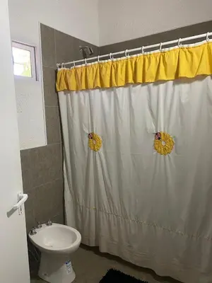 a bathroom with a shower curtain and a toilet at Casa Paz in Santa Rosa de Calamuchita