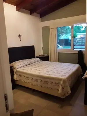 a bedroom with a bed with a cross on the wall at Cabañas Dulce Lugar - Va Ciudad Parque-Calamuchita in Villa Ciudad Parque