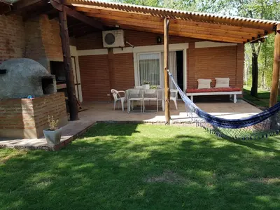 a patio with a hammock in a yard at Cabañas Dulce Lugar - Va Ciudad Parque-Calamuchita in Villa Ciudad Parque