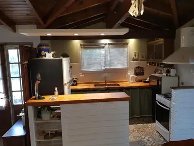 a kitchen with a counter top and a refrigerator at Cabañas Dulce Lugar - Va Ciudad Parque-Calamuchita in Villa Ciudad Parque