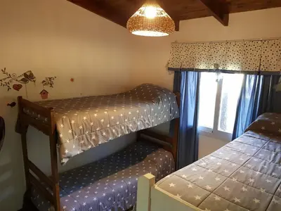 a bedroom with two bunk beds and a window at Cabañas Dulce Lugar - Va Ciudad Parque-Calamuchita in Villa Ciudad Parque