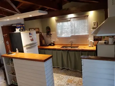 a kitchen with a white refrigerator and a sink at Cabañas Dulce Lugar - Va Ciudad Parque-Calamuchita in Villa Ciudad Parque