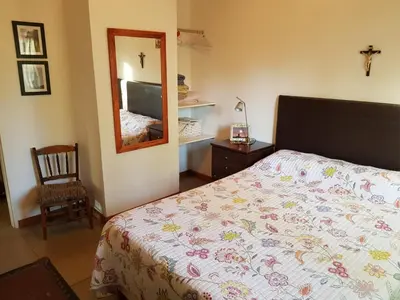 a bedroom with a bed and a mirror and a chair at Cabañas Dulce Lugar - Va Ciudad Parque-Calamuchita in Villa Ciudad Parque
