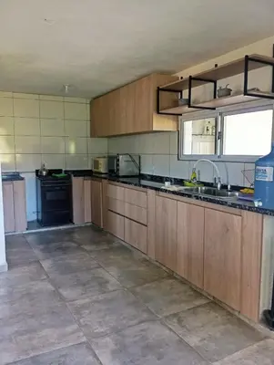 a large kitchen with wooden cabinets and a sink at La Cautivadora, Potrero de Garay in Potrero de Garay