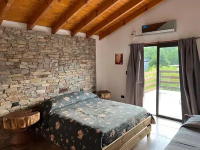 a bedroom with a bed and a stone wall at Casa Isolina in Arroyo de Los Patos