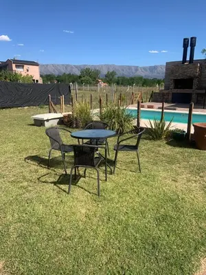 a table and chairs in a yard with a pool at Casa Isolina in Arroyo de Los Patos