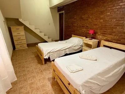 a room with two beds and a staircase at Cabaña en villa de las Rosas in Villa de Las Rosas