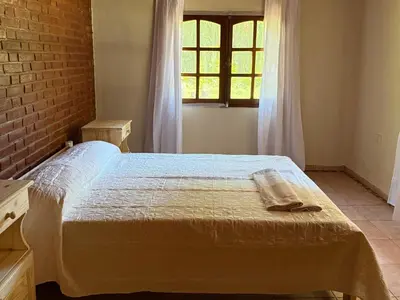 a bedroom with a bed and a window at Cabaña en villa de las Rosas in Villa de Las Rosas