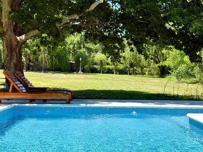 a swimming pool with a chair next to a tree at Cabaña en villa de las Rosas in Villa de Las Rosas