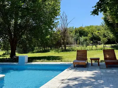 two wooden chairs sitting next to a swimming pool at Cabaña en villa de las Rosas in Villa de Las Rosas