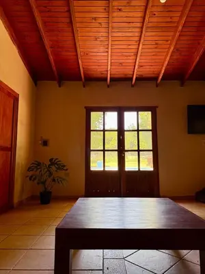 a room with a wooden ceiling and a wooden table at Cabaña en villa de las Rosas in Villa de Las Rosas