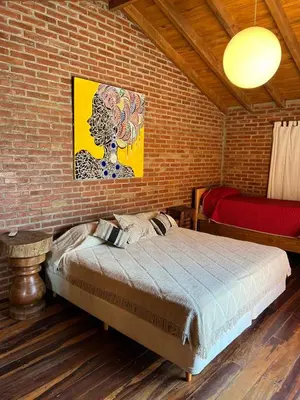 a bedroom with a bed and a brick wall at Casa Isolina II in Arroyo de Los Patos