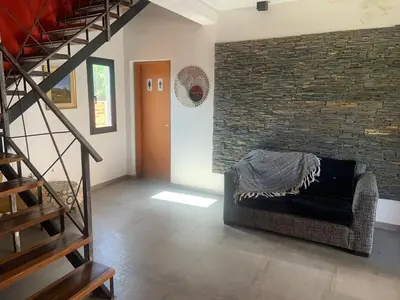 a living room with a couch and a brick wall at Casa Isolina II in Arroyo de Los Patos