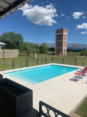 a swimming pool with a chair and a building at Casa Isolina II in Arroyo de Los Patos