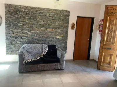 a chair sitting in a room with a brick wall at Casa Isolina II in Arroyo de Los Patos