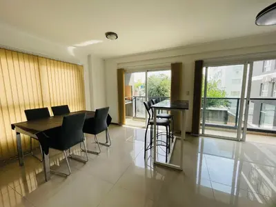a dining room with a table and chairs and windows at Veneto VIII in Villa Carlos Paz