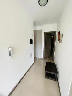 a white room with a table and a clock on the wall at Veneto VIII in Villa Carlos Paz