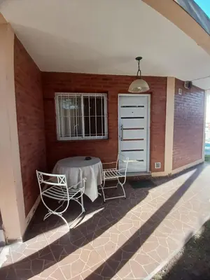 a patio with two chairs and a table and a window at Los tamarindos in Villa Carlos Paz