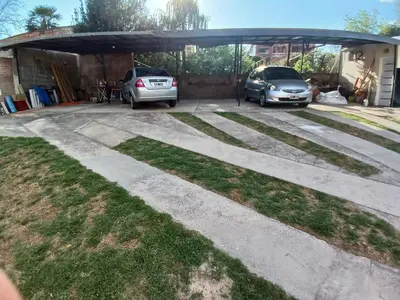 a driveway with two cars parked in a garage at Los tamarindos in Villa Carlos Paz