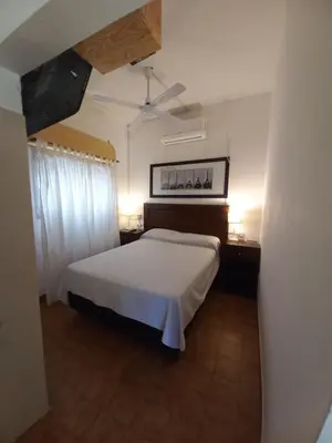 a bedroom with a white bed and a ceiling at El Nogal Mina Clavero in Mina Clavero