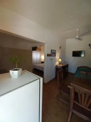 a room with a kitchen and a living room with a table at El Nogal Mina Clavero in Mina Clavero