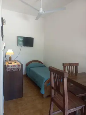 a bedroom with a bed and a table and a tv at El Nogal Mina Clavero in Mina Clavero