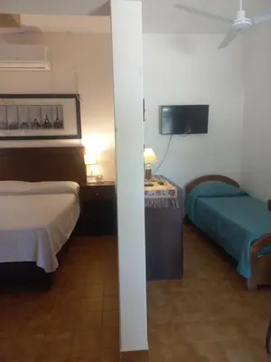 a hotel room with two beds and a flat screen tv at El Nogal Mina Clavero in Mina Clavero
