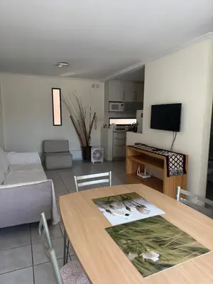 a living room with a table and a kitchen at Salguero 10 in Cordoba