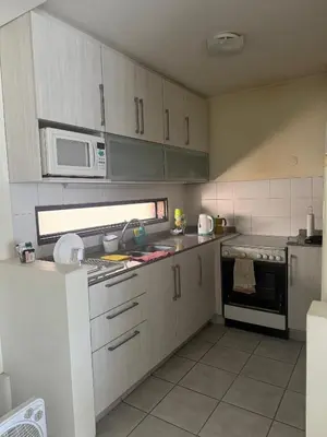 a kitchen with white cabinets and a stove and microwave at Salguero 10 in Cordoba