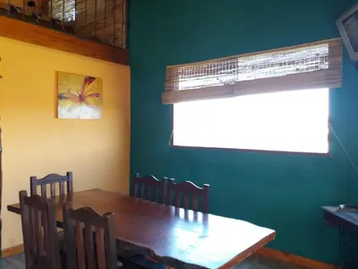 a dining room with a wooden table and chairs at Cabaña parque siquiman in Villa Parque Siquiman