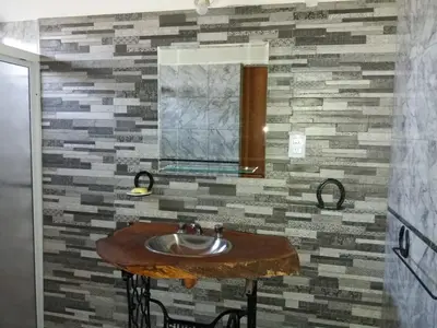a bathroom with a sink with a stone wall at Cabaña parque siquiman in Villa Parque Siquiman