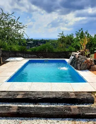 a small swimming pool with a stone walkway around it at Cabaña parque siquiman in Villa Parque Siquiman