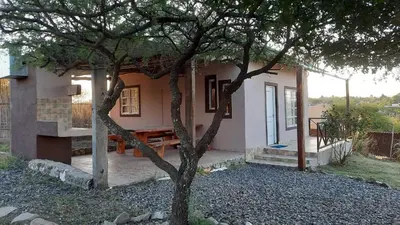 a small house with a tree in front of it at Cabaña parque siquiman in Villa Parque Siquiman