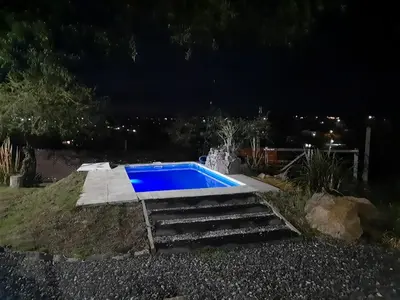 a swimming pool in a yard at night at Cabaña parque siquiman in Villa Parque Siquiman