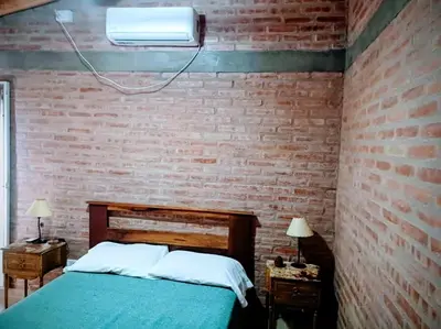 a bedroom with a brick wall and a bed at Cabañas La Morena in Panaholma