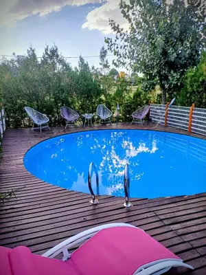 a swimming pool with chairs and a table on a wooden deck at Cabañas La Morena in Panaholma