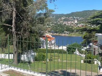 a view of a lake through a fence at ALOJATE PREMIUM CARLOS PAZ Oasis in Villa Carlos Paz