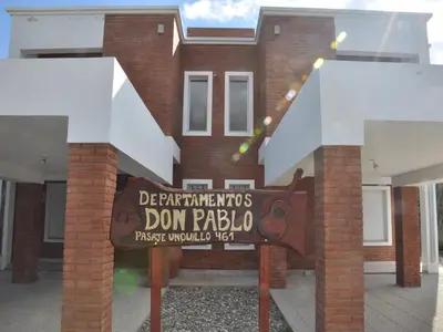 a house with a sign in front of it at Cabañas Don Pablo in Mina Clavero