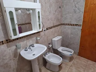 a bathroom with a sink and a toilet and a mirror at Cabañas Don Pablo in Mina Clavero