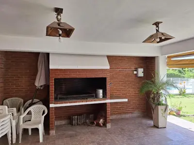 a fireplace in a living room with a brick wall at Cabañas Don Pablo in Mina Clavero