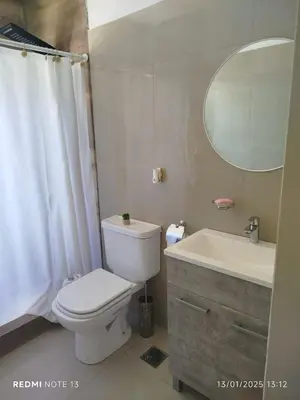 a bathroom with a toilet and a sink and a mirror at Mountain View & Comfort in Villa Santa Cruz del Lago