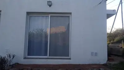 a window on the side of a white house at Mountain View & Comfort in Villa Santa Cruz del Lago