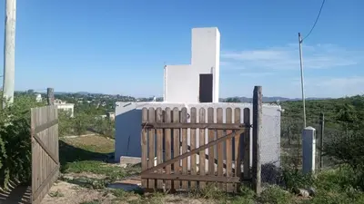a wooden gate in front of a white building at Mountain View & Comfort in Villa Santa Cruz del Lago