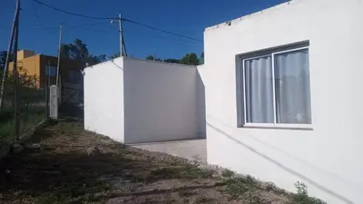 a white building with a window next to a fence at Mountain View & Comfort in Villa Santa Cruz del Lago