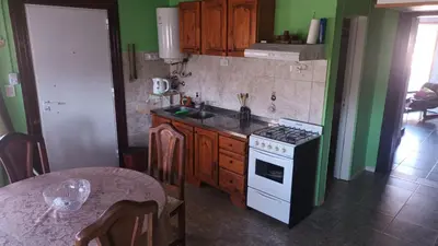 a kitchen with a stove and a table in it at La Casa Del Rio in Villa Santa Cruz del Lago