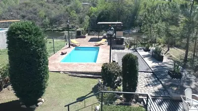 a swimming pool in a yard with trees at La Casa Del Rio in Villa Santa Cruz del Lago
