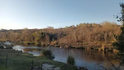 a river with rocks in the water and trees at La Casa Del Rio in Villa Santa Cruz del Lago