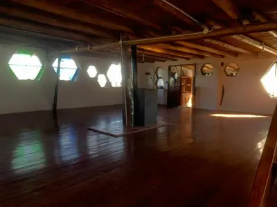 an empty room with a wooden floor and windows at Casa de Miel in Los Molles