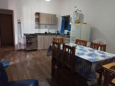 a kitchen with a table and a table and chairs at La Calma in Villa Yacanto