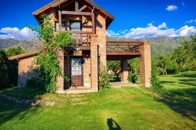 a brick house with a balcony on a green lawn at Tayimapu in Merlo
